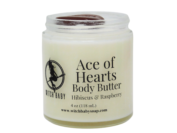 white body butter packaged in glass jar with red jasper on top and clear label that reads: Ace of Hearts body butter. Hibiscus & Raspberry. 