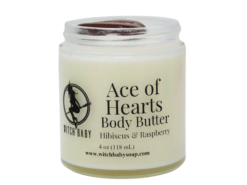 white body butter packaged in glass jar with red jasper on top and clear label that reads: Ace of Hearts body butter. Hibiscus & Raspberry. 