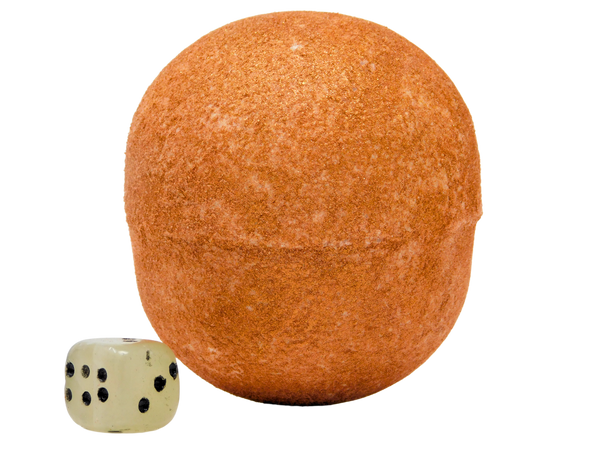 gold glitter covered sphere shaped bath bomb with jade dice