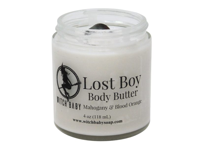 grey body butter in 4 oz glass jar topped with bloodstone. packaged with clear label that reads: Lost Boy Body Butter. Mahogany & Blood Orange. 