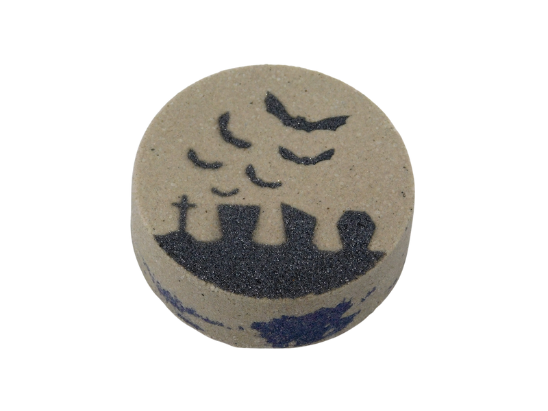 gray bath bomb with graveyard scene and purple at the center of the bath bomb