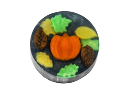 circular soap with a pumpkin, swirling autumn leaves, and a black background