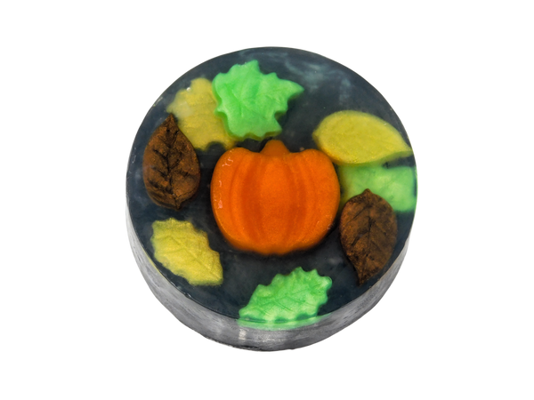 circular soap with a pumpkin, swirling autumn leaves, and a black background