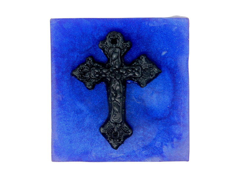 A squared shaped purple soap that smells like violets and sugar topped with a black cross.