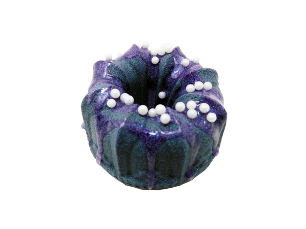 dark indigo bundt cake shaped bath bomb drizzled with purple soap with pearlescent sprinkles on top