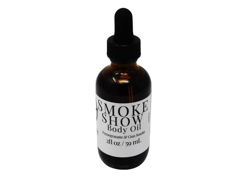 Smoke Show Body oil in a 2 oz glass dropper bottle with a white label that reads: Smoke Show Body Oil. Pomegranate & Gun Smoke.