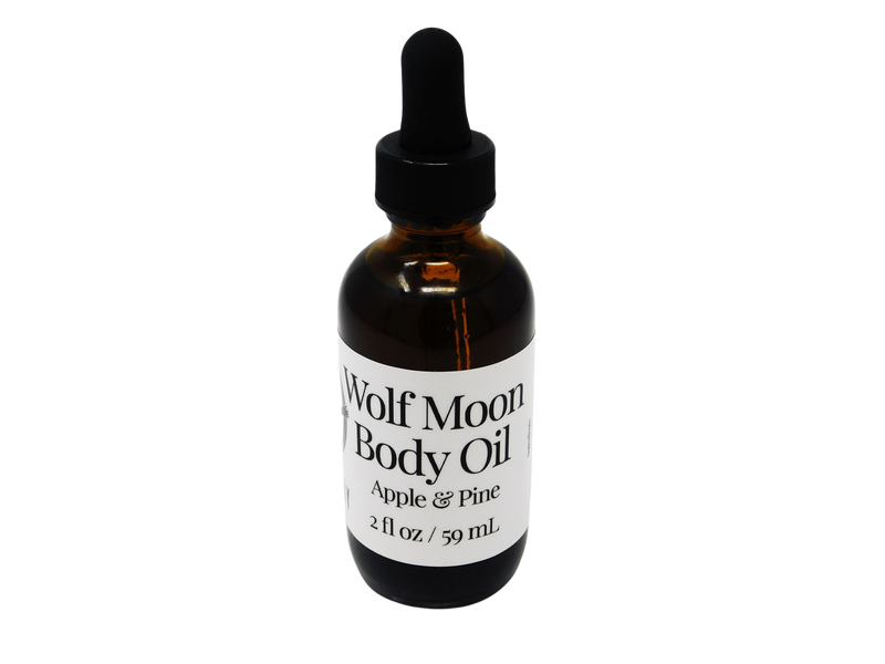 brown glass dropper bottle with white label that reads: Wolf Moon Body Oil. Apple & Pine. 