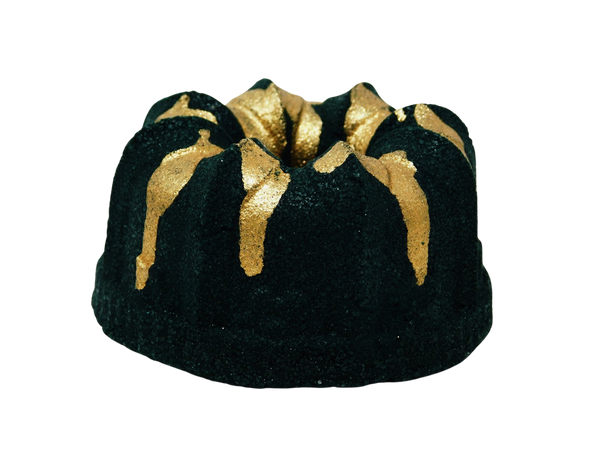 Black cake shaped bath bomb with gold glitter dripped on top. 