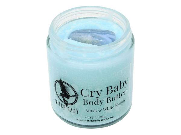 4 oz glass jar of baby blue Cry Baby body butter topped with a blue lace agate crystal