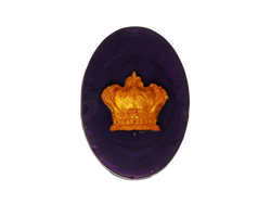 Deep plum colored oval soap with a gold crown on top.