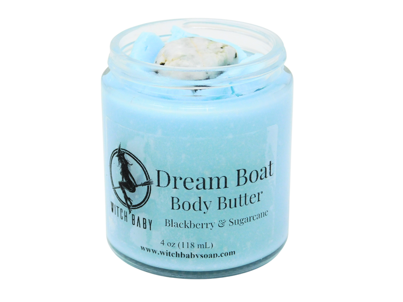 Sky blue body butter in 4 oz glass jar topped with lid removed to reveal rainbow moonstone. Label reads: Dream Boat Body Butter. Blackberry & Sugarcane. 