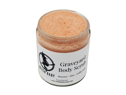 Think pink buttery scrub speckled with salt granules in glass 8 oz (236 mL) jar. White label readS: Graveyard Body  Scrub. Flowers - Dirt - Coffin Satin.