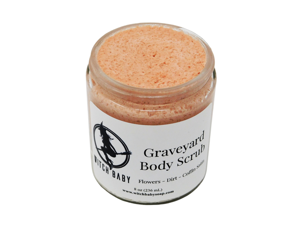 Think pink buttery scrub speckled with salt granules in glass 8 oz (236 mL) jar. White label readS: Graveyard Body  Scrub. Flowers - Dirt - Coffin Satin.