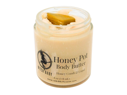Honey colored body butter in 8 oz glass jar. Topped with yellow jasper. Label says Honey pot body butter honey comb and copal