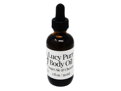 photo of lucy purr body oil in  2 oz glass dropper bottle with a white label that reads: Lucy Purr Body Oil. Ginger Ale & Cherries. 