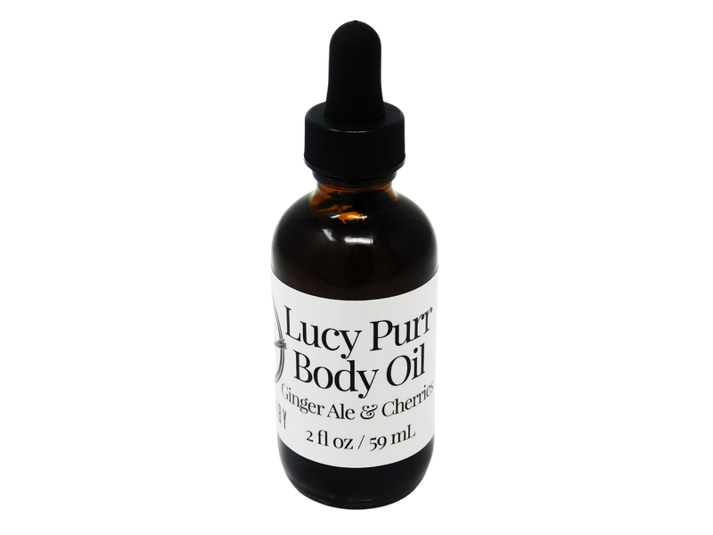 photo of lucy purr body oil in  2 oz glass dropper bottle with a white label that reads: Lucy Purr Body Oil. Ginger Ale & Cherries. 