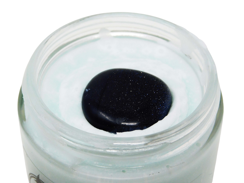 Close up on the top of Moon Dust Body Butter with the lid off. Shows a glittering blue goldstone crystal embedded into the top of a light blue body butter.