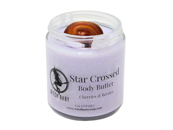 light purple body butter topped with a carnelian crystal in a 4 oz  glass jar with a clear label that says Star  Crossed Body Butter. Cherries & Berries. 